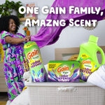 Lifestyle scene with smiling person and a laundry basket showing Gain Odor Defense detergent, softener, beads and dryer sheet box on display