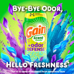 Vibrant promotional image of Gain +odor defense scent booster bottle with colorful powder and blue and purple petal graphics