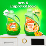 Comparison graphic showing old and new green Gain fabric softener bottles with 'new & improved look' text