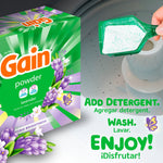 Gain powder box beside a scoop of powdered detergent being added into a washing machine drum with usage text
