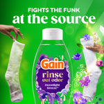 Gain Rinse bottle centered with two socks and text 'fights the funk at the source' on a bright green background with floral accents.