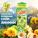 Gain scent booster bottle staged outdoors among yellow flowers and a hot-air balloon with slogan text.