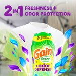 Gain Scent Booster +odor defense bottle overlaid on a white T-shirt with purple and blue petal graphics and 2-in-1 freshness claim