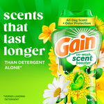 Bright promotional graphic showing Gain in-wash scent booster bottle beside text 'scents that last longer' with daisy and floral artwork.