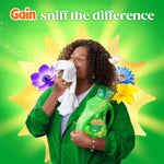 Lifestyle-style promotional image of a person smelling a cloth while holding a Gain Original detergent bottle with floral accents.