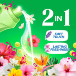 Pouring liquid from a green softener bottle with floral accents and icons for 'soft touch' and 'lasting freshness' on green background