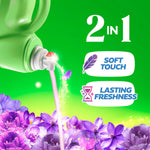 Pouring spout of a green Gain fabric softener bottle pouring liquid over a field of purple flowers with soft-touch and lasting freshness icons