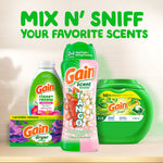 Lifestyle product grouping with Gain Tango scent booster alongside other Gain laundry products and large headline text