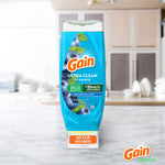 Single upright blue Gain Ultra Clean EZ‑Squeeze bottle (honey berry) on marble counter with blurred kitchen background
