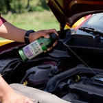 Hand-held Gear Hugger Eco degreaser spraying a thin stream into a car engine bay from above the engine components.