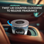 Gel can placed in a car cupholder with instruction banner 'Twist lid counter-clockwise to release fragrance'