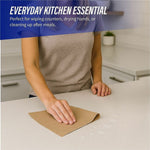 Person wiping a kitchen countertop with a brown paper towel, text reads everyday kitchen essential