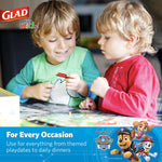 Two young children playing at a table with Glad for Kids logo and Paw Patrol promotion banner below