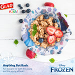 Top-down lifestyle photo of a Glad Frozen paper bowl filled with granola and strawberries on a white wood surface