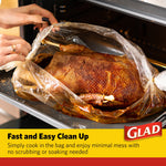 Cooked poultry inside a clear oven bag on a baking tray with hands opening the bag
