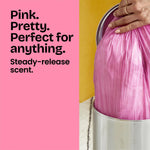 Lifestyle image of hands tying a pink trash bag into a stainless pedal bin with pink text panel promoting steady-release scent