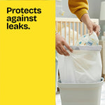 Hands placing a diaper into a white trash bag inside a small bin with yellow panel text 'Protects against leaks.'