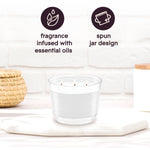 Glade three-wick candle on a surface with icons and copy noting ‘fragrance infused with essential oils’ and ‘spun jar design’.