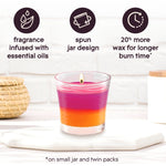 Glade candle on a surface with icons highlighting fragrance infused with essential oils, spun jar design, and 20% more wax