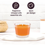 Orange Glade 3-wick candle on a surface with icons and text highlighting 'fragrance infused with essential oils' and 'spun jar design'