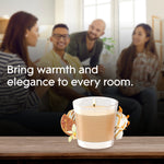 Lit Glade jar candle on a wooden surface with blurred group of people in background and headline about bringing warmth and elegance to every room