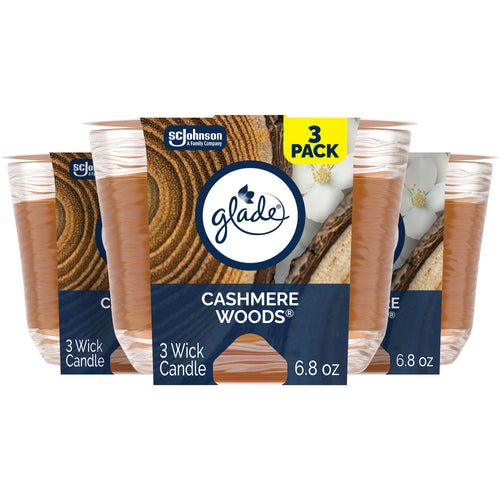 Three Glade Cashmere Woods three-wick candles in clear spun-glass jars with branded front packaging and wood-grain label.