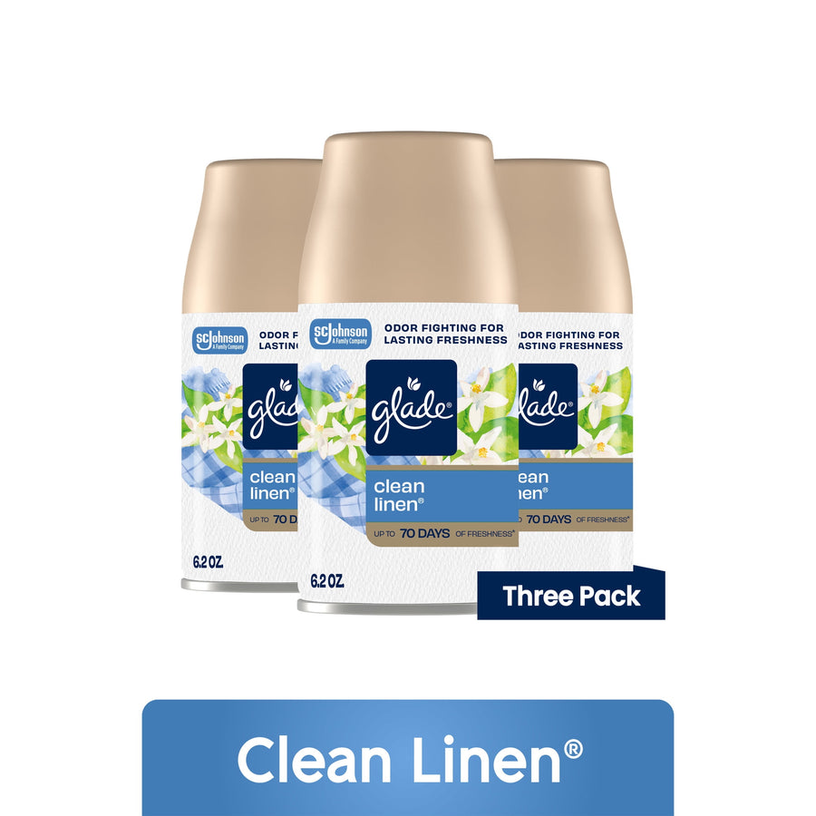 Three Glade Clean Linen automatic spray refill cans with floral label and gold caps