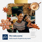 Smiling adult and child in festive room with Glade Cozy Gingerbread candle thumbnail and spice and cookie decorations