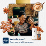 Smiling parent and child in a holiday living room with Glade dispenser and Cozy Gingerbread refill inset