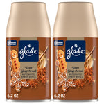 Two Glade Cozy Gingerbread automatic spray refill cans with gingerbread cookie graphics