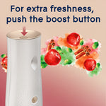 Close-up of Glade dispenser top with arrow indicating boost button and apple-cinnamon artwork behind