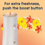 Top view of automatic dispenser showing boost button with arrow and tropical flowers indicating extra freshness boost