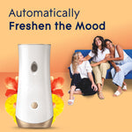 Automatic dispenser with three people seated on a sofa in background and text 'Automatically Freshen the Mood'