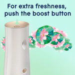 Top view of Glade automatic dispenser showing boost button with arrow and Dewdrop Petals floral graphic behind it