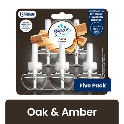 Retail blister pack of Glade plug-in scented oil refills in Oak & Amber showing five clear refill bottles and wood imagery