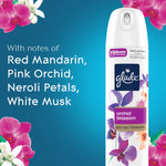 Glade Orchid Blossom aerosol can against blue background with floral accents and ingredient notes text.