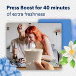 Person pressing the boost button on a Glade ScentFlow device with smiling people in background and copy about 40 minutes of extra freshness