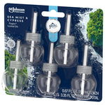 Angled front view of Glade PlugIns Sea Mist & Cypress five-pack blister with visible refill bottles and ocean-themed background