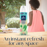 Lifestyle image of Glade soft mist spray on a table with blurred person in background and text about instant refresh