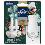Glade PlugIns starter kit blister card showing white plug-in warmer and two clear scented oil refills with pine and cedar holiday artwork