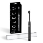 Black Gleem battery-powered toothbrush upright with white travel case and retail box on white background.