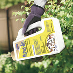 Gloved hand holding a tilted jug of Bonide Repels-All granules above garden foliage