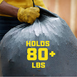 Close-up of gloved hand gripping the drawstring of a textured black trash bag with bold "HOLDS 80+ LBS" text