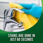 Gloved hand wiping a chrome faucet with a yellow cloth and text stating stains are gone in just 60 seconds