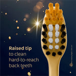 Close-up of a gold toothbrush head showing multicolored ultra-soft bristles with magical starry background
