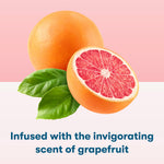Illustration of a whole and halved grapefruit with green leaves over a pink background and scent caption