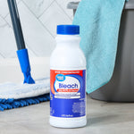 Great Value bleach bottle on a floor with cleaning tools and a bucket in a laundry or cleaning scene