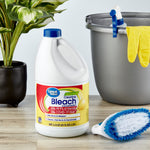 Great Value lemon-scent bleach jug staged on a table with cleaning brush, bucket and plant in a lifestyle scene