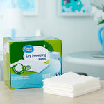 Lifestyle-style photo of Great Value dry sweeping refills box with a stack of folded white cloths on a countertop