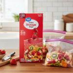 Great Value gallon storage bags box displayed on a kitchen counter beside filled resealable bags and strawberries.
